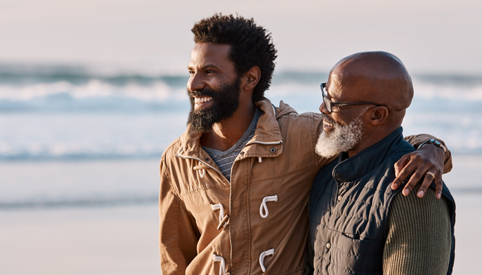 Two Men Arm In Arm Relaxing On The Beach